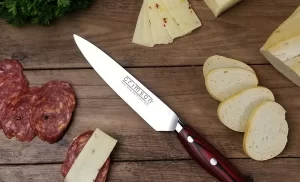 Crimson 6" Utility knife on cutting board with cheese meat and bread